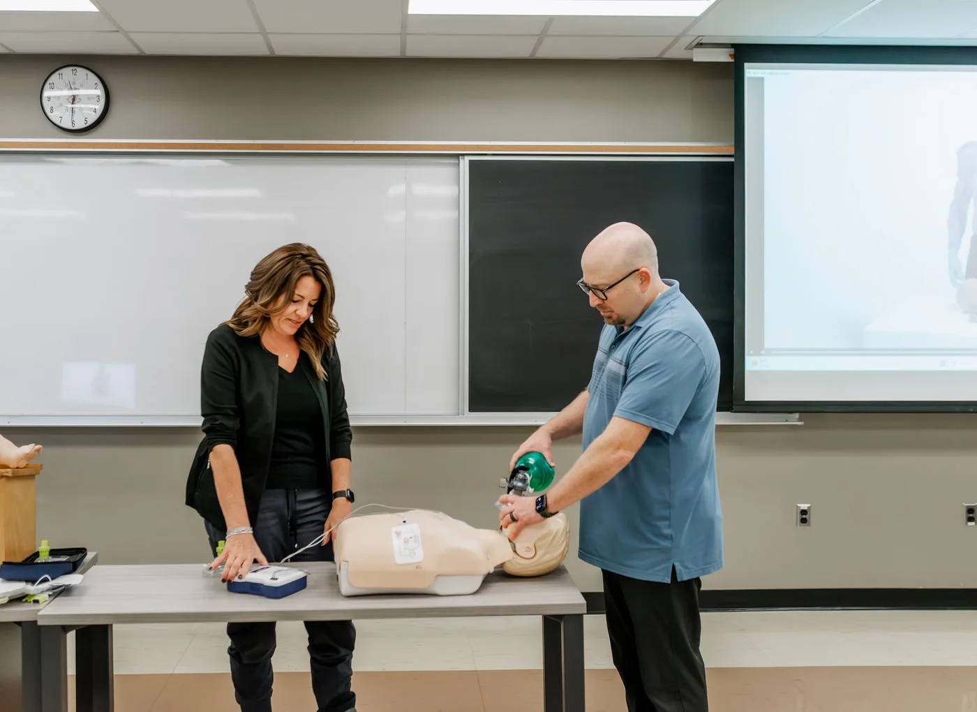 Scott and Stefanie demonstrating CPR in a classroom.